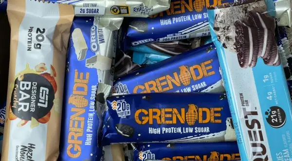 Ein bunter Haufen von Proteinriegeln, darunter Grenade und Quest. Ein Powerriegel-Test für Sportler.