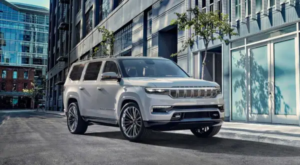 Elegancki, biały Wagoneer parkuje na miejskiej ulicy, obok nowoczesnych budynków.