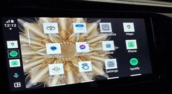 Ekran samochodu z interfejsem Android Auto. Widoczne ikony aplikacji: Toyota, Calendar, GameSnacks, Maps, Messenger, News, Phone, Spotify, Podcasts, Reminder, Settings.