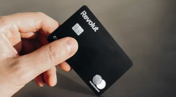 Dłoń trzyma czarną kartę Revolut Business z logo Mastercard.
