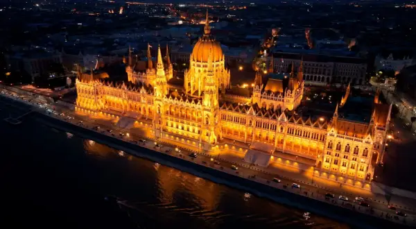 Budynek Parlamentu w Budapeszcie nocą, oświetlony na złoto. Idealne miejsce na Sylwestra, jeśli znajdziesz tanie loty na Sylwestra.