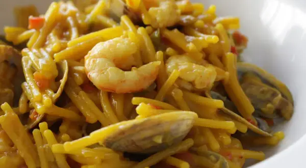 Fideos con almejas y gambas, un plato de marisco delicioso y lleno de sabor.