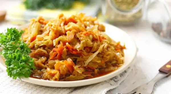 Piatto di verza stufata con carote, guarnito con prezzemolo. Un classico sapore di verza stufata ricetta della nonna.