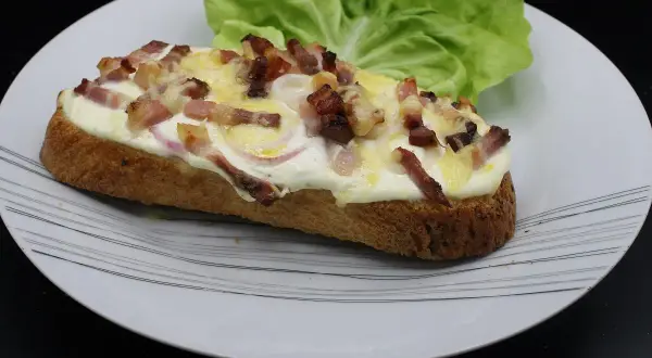 Bruschetta gourmande avec lardons croustillants, oignons rouges et fromage fondant. Un délice pour les amateurs de bruschetta fromage.