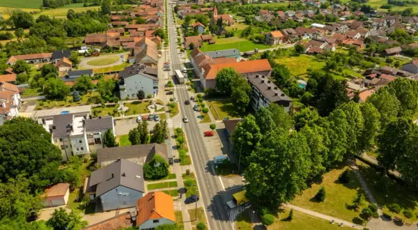 Widok z lotu ptaka na spokojne miasteczko, gdzie zielone pola przeplatają się z dachami domów. Odkryj urokliwe śrem atrakcje i poczuj atmosferę sielskiego życia.