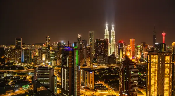 Nocna panorama Kuala Lumpur z wieżami Petronas. Kiedy najlepiej lecieć do Kuala Lumpur? Warto rozważyć okres od czerwca do września, gdy jest mniej deszczowo.