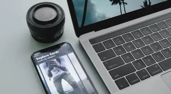 Aparat, smartfon i laptop leżą obok siebie. Zastanawiasz się, jak przesłać zdjęcia z aparatu na laptop? To proste!