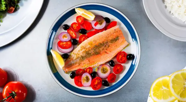 Une belle recette de truite avec tomates cerises, olives noires, oignons rouges et quartiers de citron. Un plat savoureux et coloré.