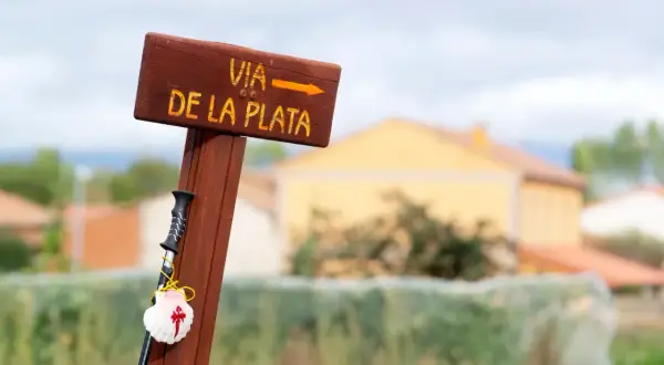 Drewniany drogowskaz Via de la Plata z muszlą pielgrzyma i laską.
