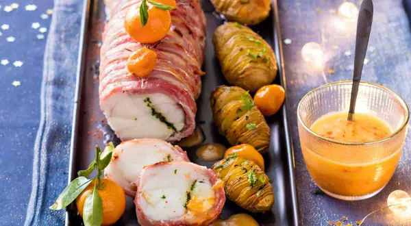 Lotte au lard, un plat festif du carnet de Julie, servi avec des pommes de terre Hasselback et une sauce orangée.
