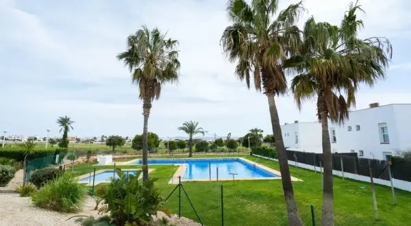 Un complejo con piscinas y palmeras, ideal para disfrutar del sol. El toyo retamar ofrece un oasis de tranquilidad.