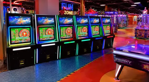 Rząd podświetlanych maszyn do gry zręcznościowej w "Fun Zone", gdzie każdy może spróbować szczęścia.