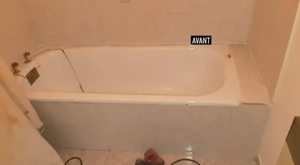 Salle de bain avant rénovation baignoire : baignoire blanche fissurée, robinetterie ancienne, carrelage beige.