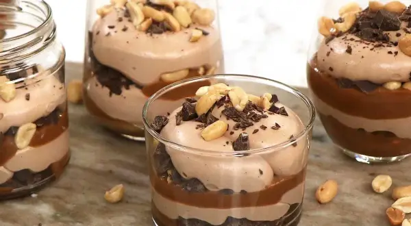 Chokladmousse-desserter i glas med lager av choklad, kolasås och jordnötter. En härlig rocky road-upplevelse!