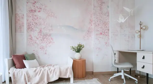 Delikatna fototapeta IKEA z kwitnącą wiśnią tworzy sielankową atmosferę w pokoju z łóżkiem i biurkiem.