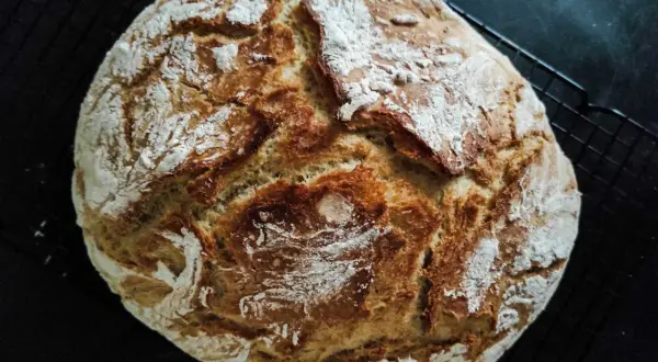 Chleb swojski, pachnący domem, z chrupiącą skórką i miękkim wnętrzem, czeka na rozkrojenie.