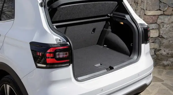 Bagagliaio aperto di un'auto bianca, con un'ampia capacità di carico, perfetta per ogni tipo di viaggio, anche con bagagli di grandi dimensioni.