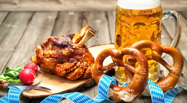Un saporito stinco di maiale arrosto, due brezel e una birra bionda, un classico cibo da oktoberfest.