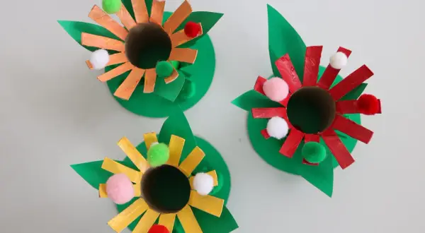Roliga pysseltips med toarullar! Tre färgglada blommor av toarullar, papper och fluffiga bollar. Perfekt för barnens pysselstund.