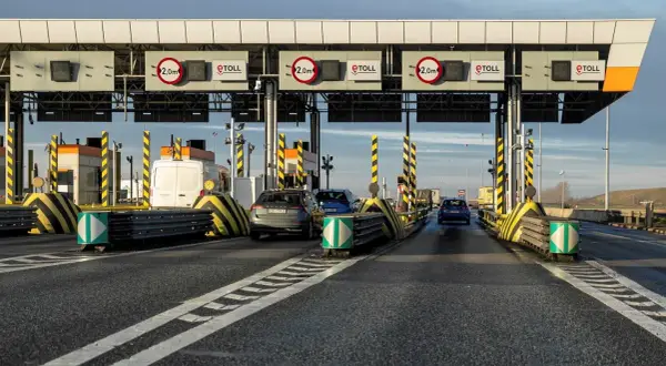 Bramki autostradowe e-TOLL z samochodami i znakami ograniczenia wysokości.