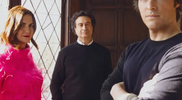 Jaime Renedo chef, con dos acompañantes, posa frente a una ventana de celosía y una puerta de madera.