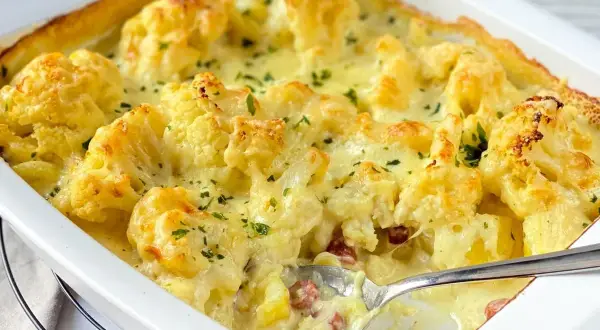 Ein cremiger Blumenkohl Kartoffel Auflauf mit Käse überbacken, garniert mit Petersilie. Perfekt für ein herzhaftes Abendessen.
