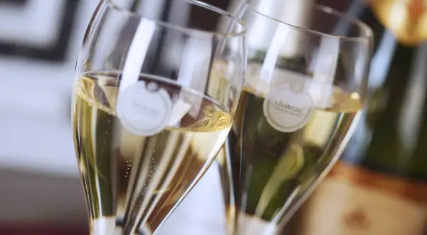 Zwei Gläser mit Champagner, die verschiedene Champagner-Sorten repräsentieren. Bläschen steigen auf.