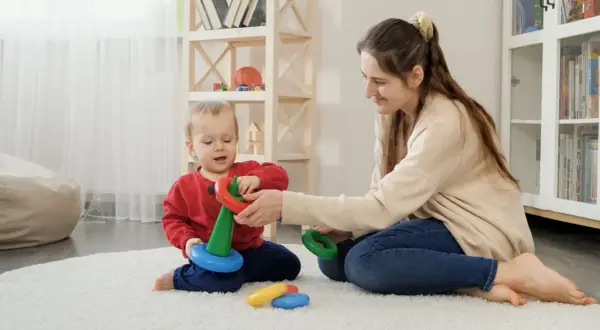 Mama i dziecko bawią się kółkami, rozwijając zdolności motoryczne. Radość i nauka w jednym.