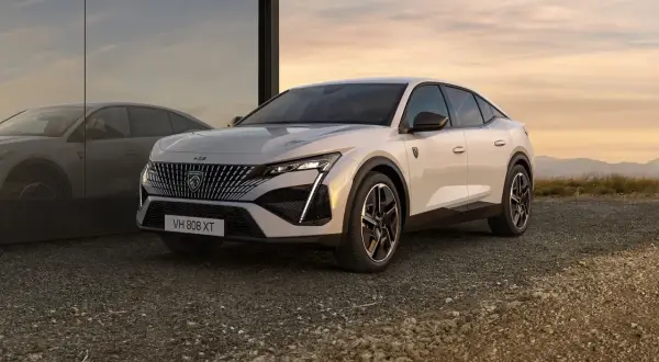 Nowy Peugeot 408 w kolorze białym, z charakterystycznym grillem i nowoczesnymi światłami. Sprawdź jego atrakcyjną peugeot 408 cenę.