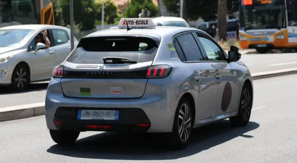 Voiture auto-école Peugeot 208 argentée, avec un autocollant "Votre permis B FINANCE grâce au CPF".