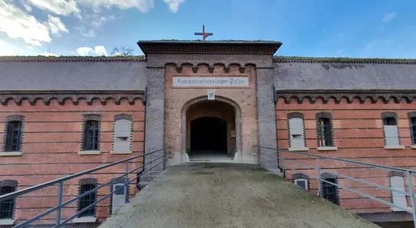 Fort Poznań, dawniej obóz koncentracyjny, z charakterystycznym łukiem i napisem.
