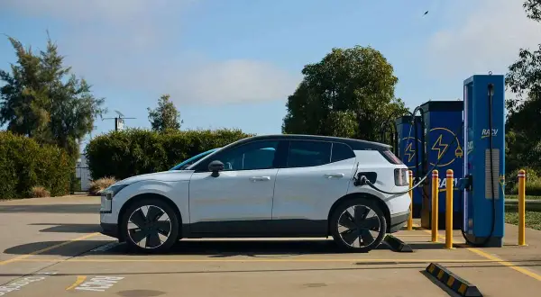 Voiture électrique blanche branchée à une borne de recharge. Un avantage véhicule électrique : l'énergie propre pour un avenir durable.
