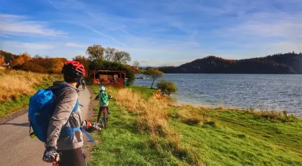 Rodzina na rowerach podziwia jesienne krajobrazy nad jeziorem. Trasa velo Czorsztyn GPX zapowiada się wspaniale!
