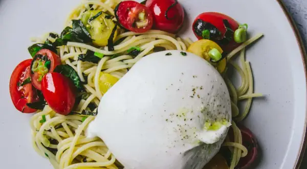 Une burrata crémeuse sur des pâtes aux tomates cerises et basilic. Une recette simple et savoureuse.