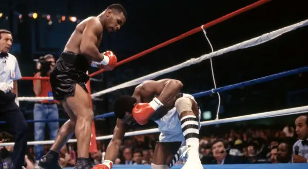Mike Tyson lands a powerful punch, sending his opponent to the canvas. A classic example of the best Mike Tyson knockouts.
