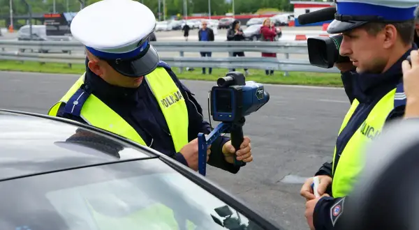 Policjant mierzy prędkość. Kierowca przekroczył prędkość o 30 km/h.