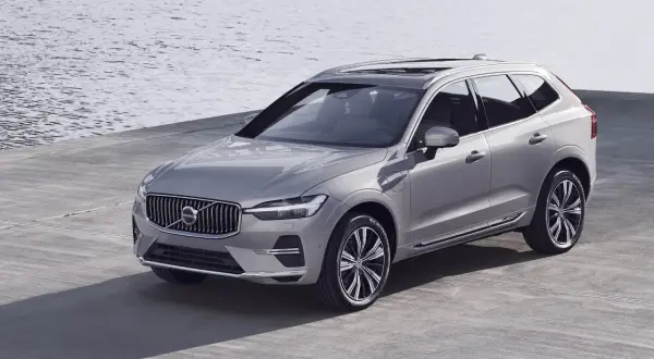 Elegancki, srebrny Volvo XC60 T6 prezentuje się nad wodą.