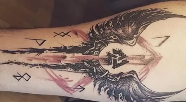 Tatuaż walka z samym sobą: symbolika run i skrzydła na przedramieniu.