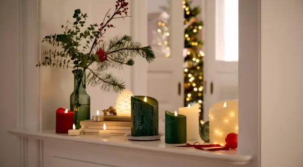 Gemütliche weihnachtsdeko tipps: Kerzen, Tannenzweige und Lichterketten schaffen festliche Stimmung.