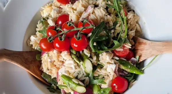 Leckerer Nudelsalat mit Spargel, Kirschtomaten, Feta und Rucola. Ein frischer Genuss!