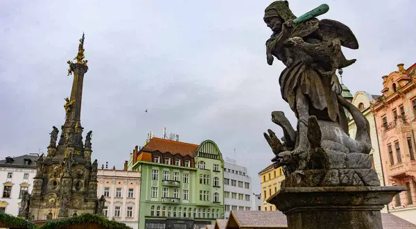 Fuente barroca y columna de la peste en Brno. Un buen lugar que ver en Brno, con edificios coloridos de fondo.