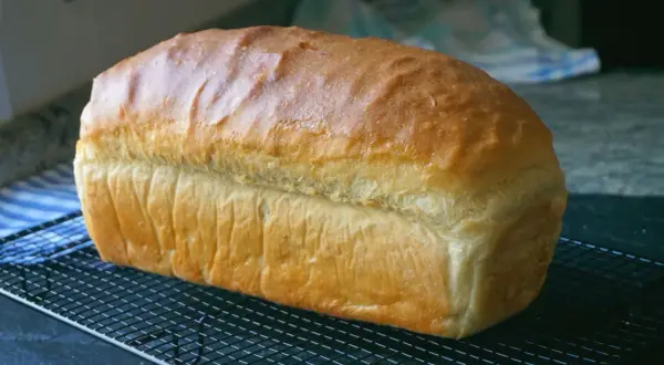 Pan de molde dorado y esponjoso enfriándose en una rejilla, perfecto para tus próximas recetas con pan de molde.