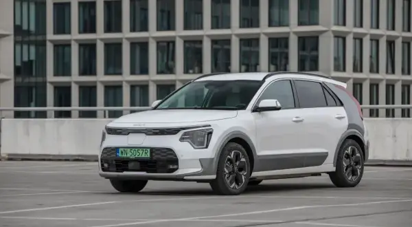 Białe Kia Niro stoi na parkingu. Sprawdź kia niro wymiary, by poznać jego kompaktowe gabaryty idealne do miasta.