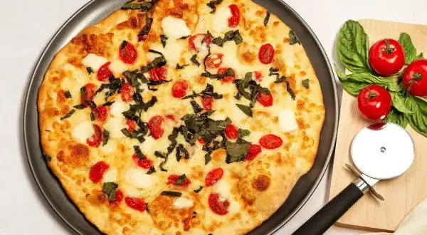 Pizzerinki z serka wiejskiego, z pomidorkami i bazylią, gotowe do pokrojenia.