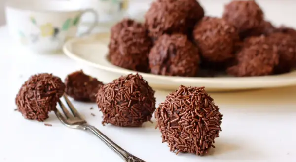 Chokladbollar, perfekta för ett arraksbollar recept. En gaffel ligger bredvid en av de chokladöverdragna godsakerna.