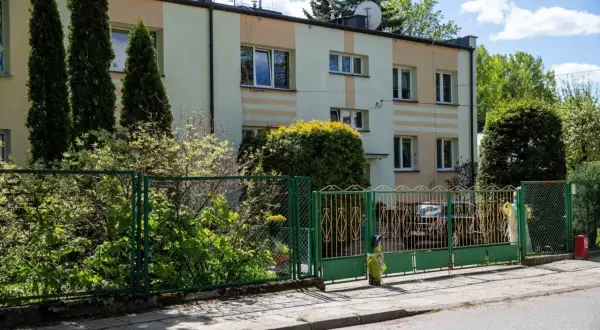 Blok mieszkalny z zielonym ogrodzeniem. Czekamy na moment, kiedy ruszy wykup mieszkań komunalnych w Warszawie, by zmienić ten widok.