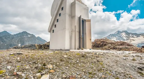 Moderne Kapelle am Pitztaler Gletscher, umgeben von felsiger Landschaft und schneebedeckten Bergen.