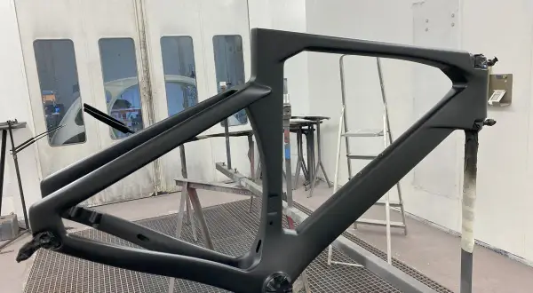 Telaio di bici in carbonio pronto per verniciare, in cabina di verniciatura.