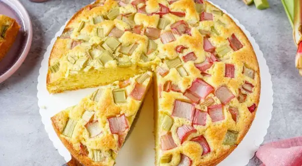 Ein saftiger Rhabarberkuchen, der aussieht wie der beste Rhabarberkuchen. Mit vielen roten und grünen Rhabarberstücken.