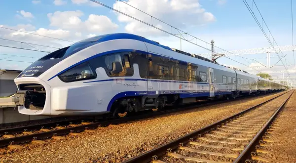Nowoczesny pociąg PKP Intercity "Dart" na torach w Pabianicach, niedaleko Łodzi, gotowy do podróży.
